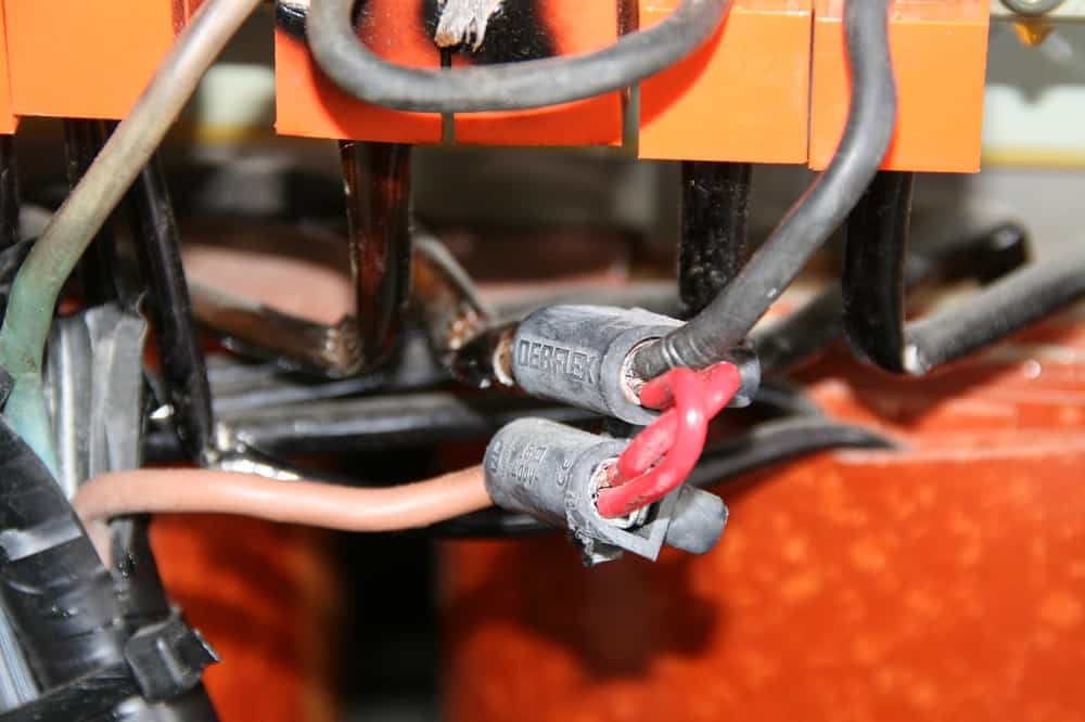 This again is a dangerous repair, the two connectors in the centre of the picture are joined together by two pieces of red cable. Two pieces of cable wired like this will not carry twice the ampage.